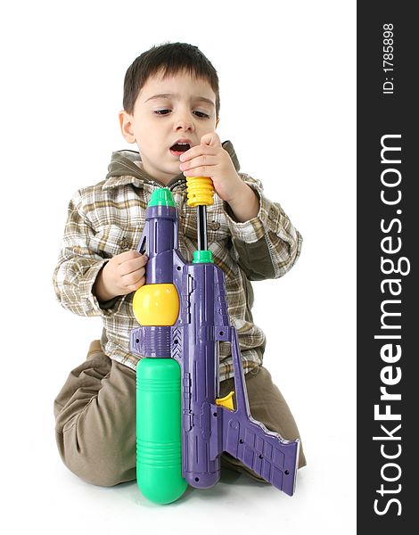 Toddler boy with water gun over white background.