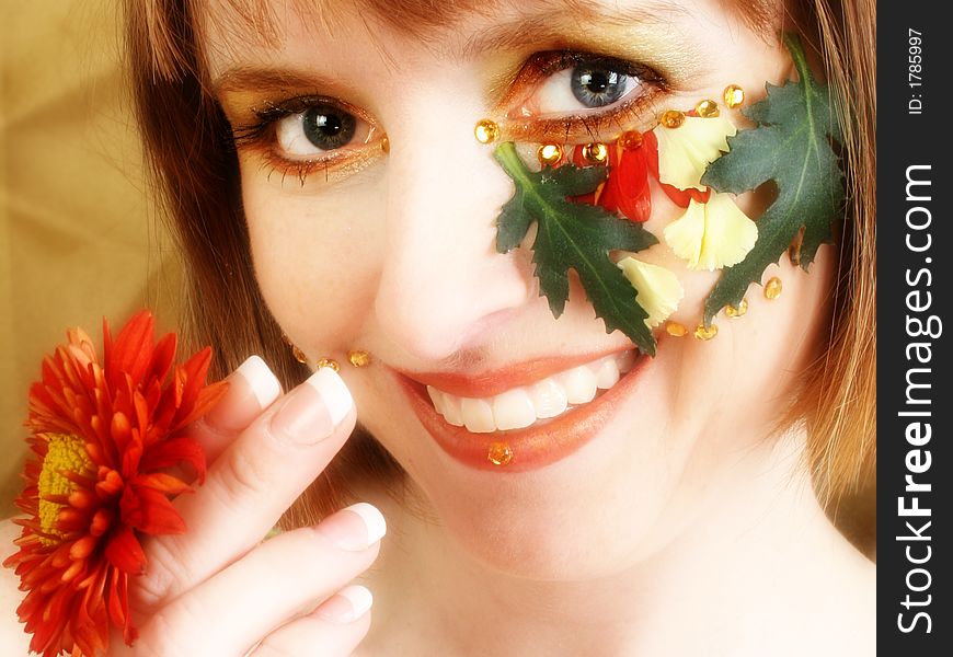 Beautiful thirty something woman with autumn flowers decorating face. Beautiful thirty something woman with autumn flowers decorating face.