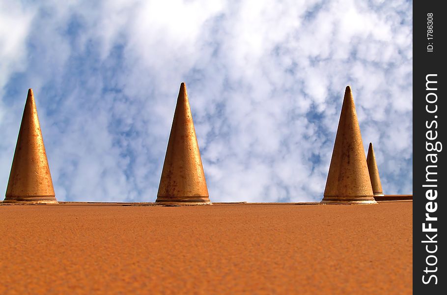 Metal cones against a blue cloudy sky