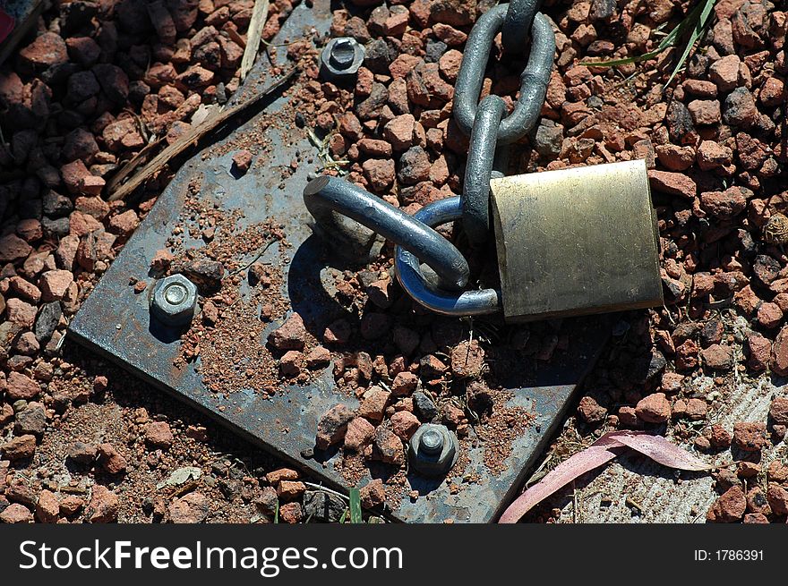 Steel chain locked into gravel ground, hot weather