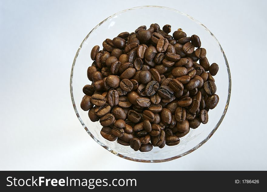 Martini glass filled with roasted coffee beans. Martini glass filled with roasted coffee beans