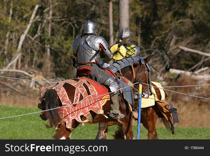 Jousting knights prepare to cladh on horseback.