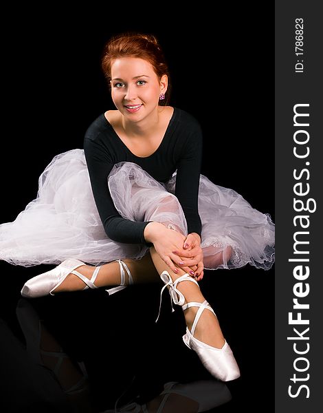 Beautiful girl ballerina to be on points on black background