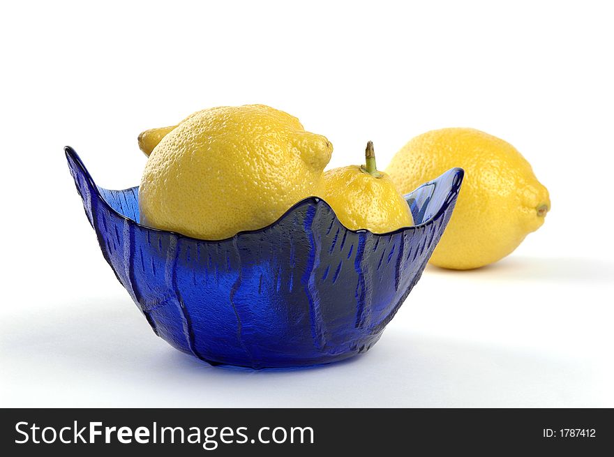 Lemons in a blue glass bowl.