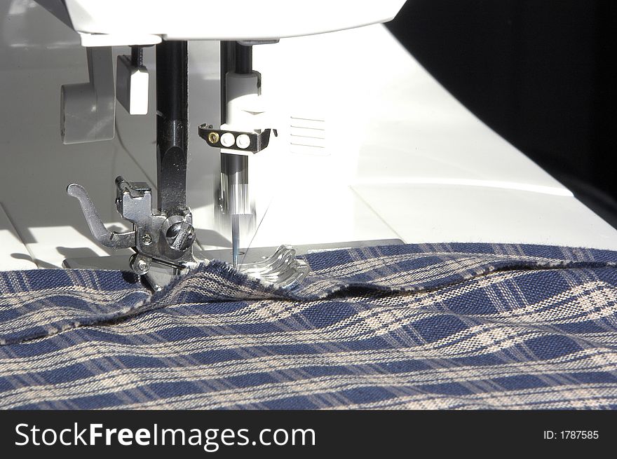 A sewing machine in the process of creating a seam on some cloth. A sewing machine in the process of creating a seam on some cloth.