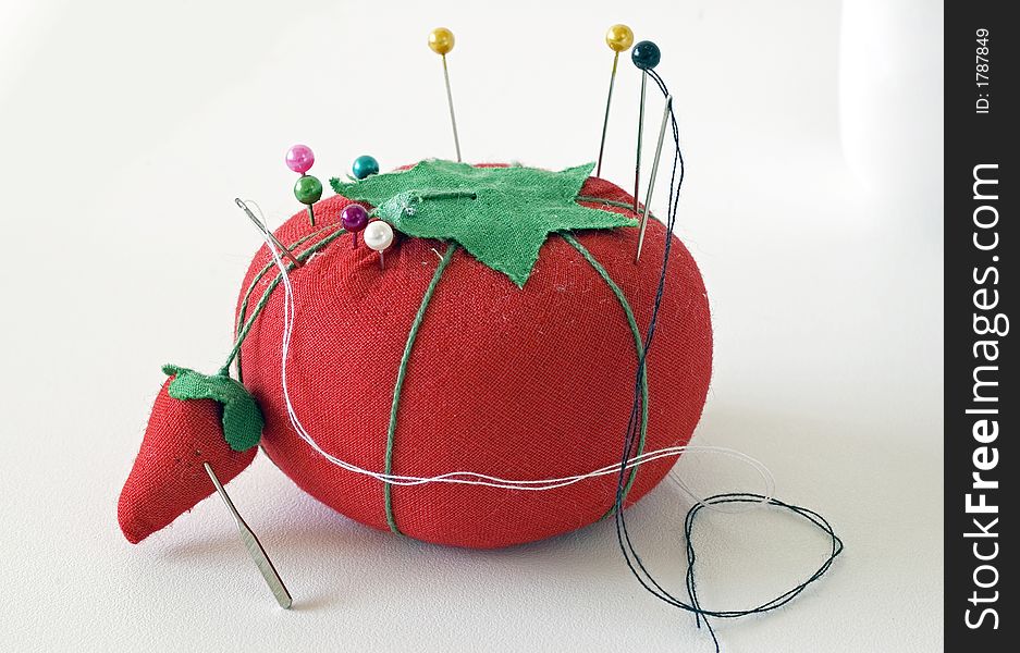 Picture of a pincushion shaped like a tomato and strawberry. Picture of a pincushion shaped like a tomato and strawberry