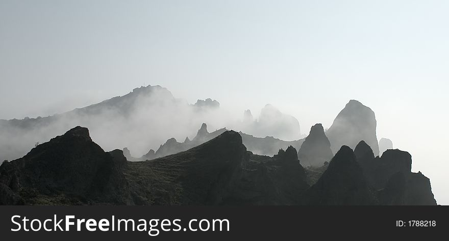 Fog floating over the grey mountain peaks. Fog floating over the grey mountain peaks