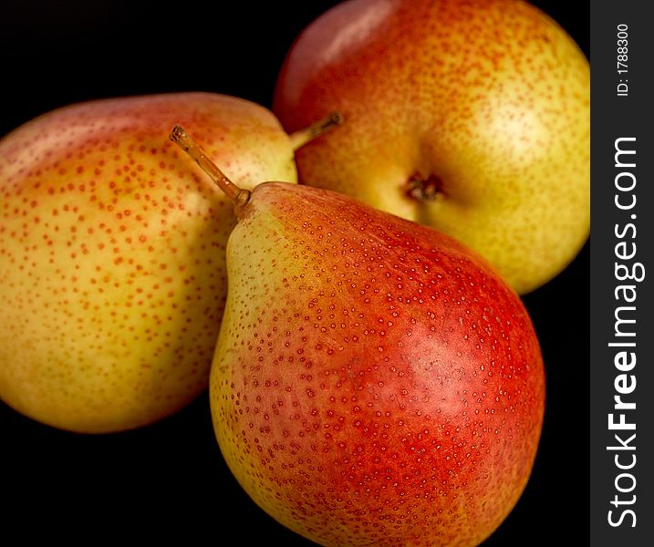 Three pears on black background, close-up