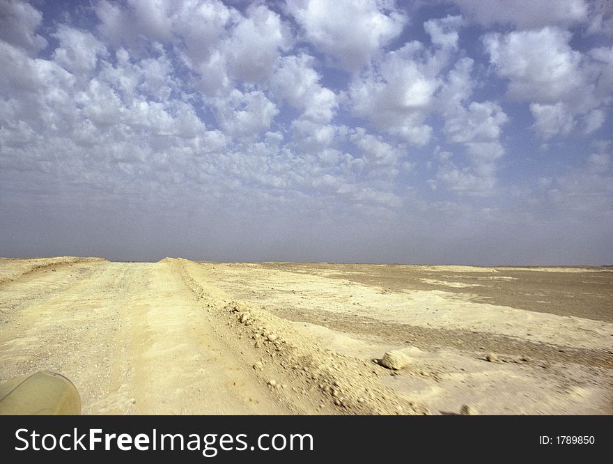 Running on a Sahara yellow track under blue and cloudy sky. Running on a Sahara yellow track under blue and cloudy sky