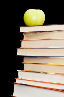Stack Of Books And Apple On A Black Background Royalty Free Stock Photography