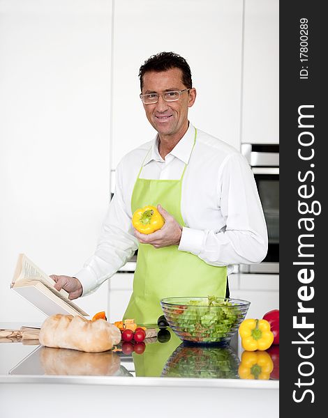 Mature man preparing food in his kitchen. Mature man preparing food in his kitchen