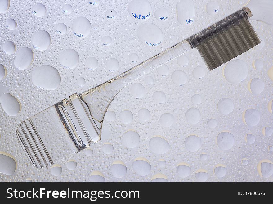 Teeth brush and water droplets refracrtion. WASH teeth refracted in water drops