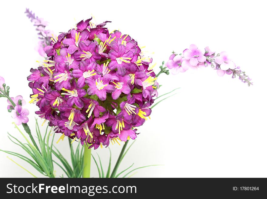 A miniature pot of plastic flowers, isolated on white