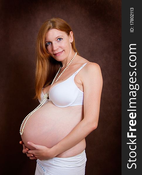 Pregnant young woman in pearl necklace
