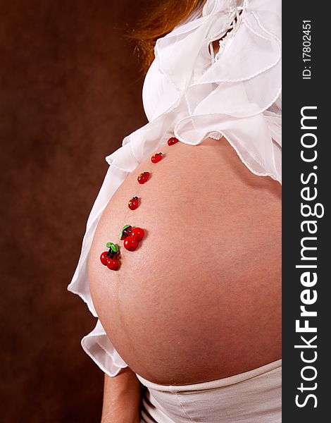 Pregnant young woman in white blose with funny motif on abdomen. Pregnant young woman in white blose with funny motif on abdomen