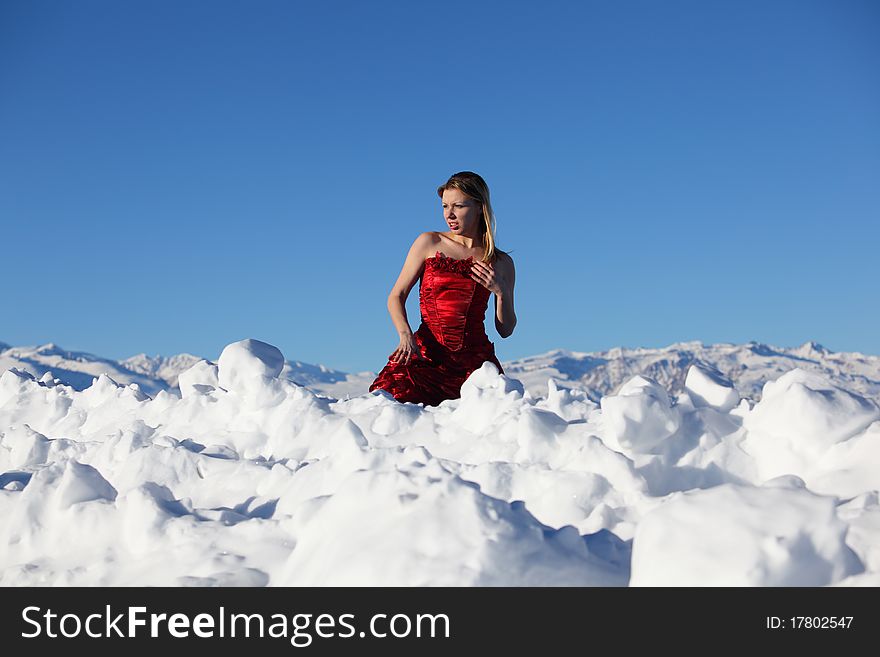 The girl in a red dress on snow
