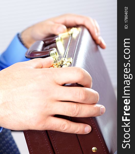 Businessman holding a brown case. Businessman holding a brown case