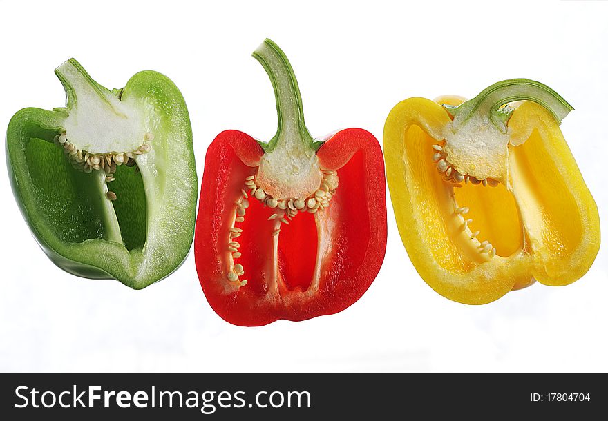 One red, one yellow and one green pepper cut in halves. One red, one yellow and one green pepper cut in halves