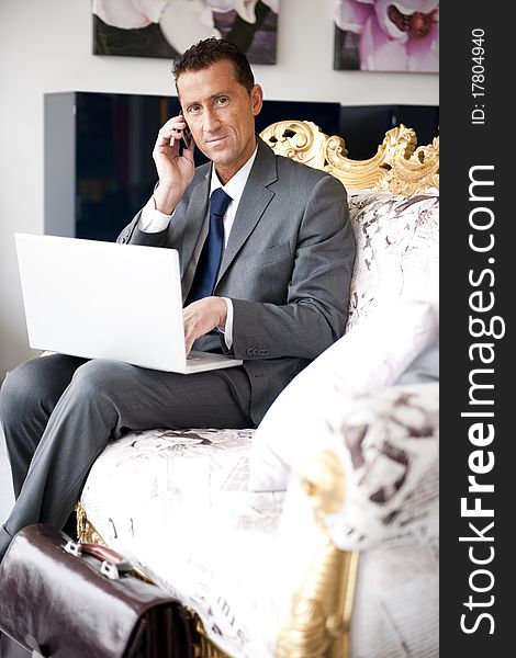 Businessman working while sitting on a vintage sofa. Businessman working while sitting on a vintage sofa