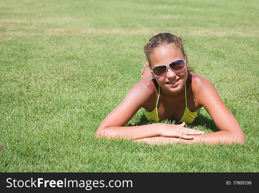 The young girl lays on a grass