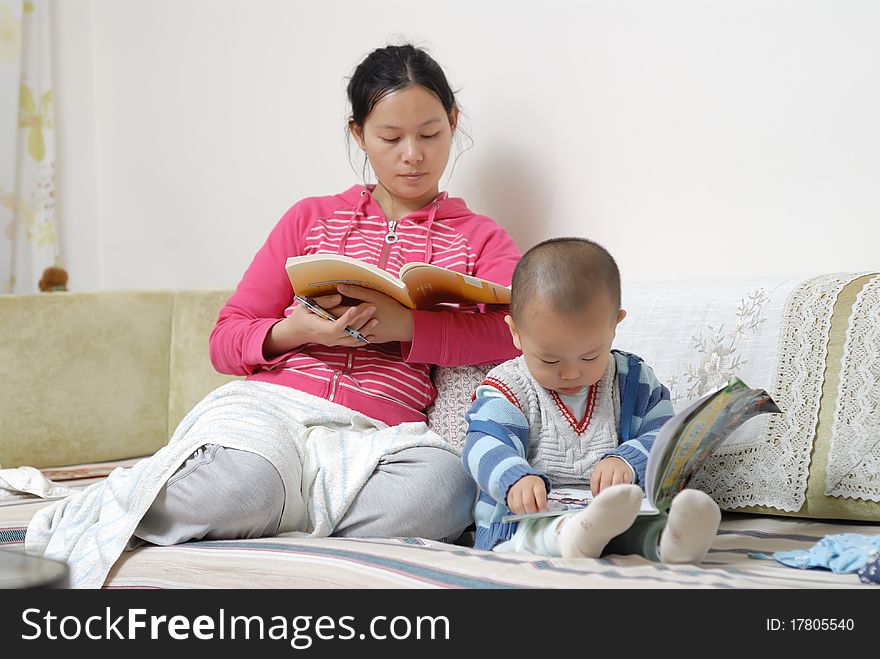 A chinese family, the mother and the boy are reading the book in home. A chinese family, the mother and the boy are reading the book in home.