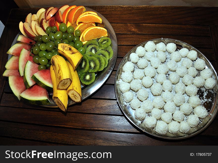 Two plates full of exotic fruit and coconut sweets. Two plates full of exotic fruit and coconut sweets