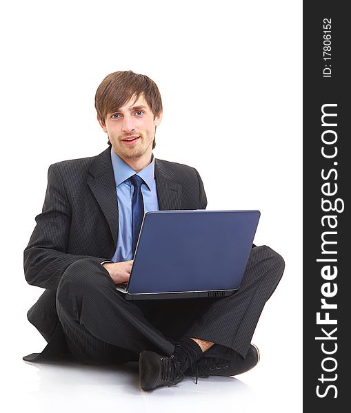 Happy young business man working on a laptop, isolated against white background