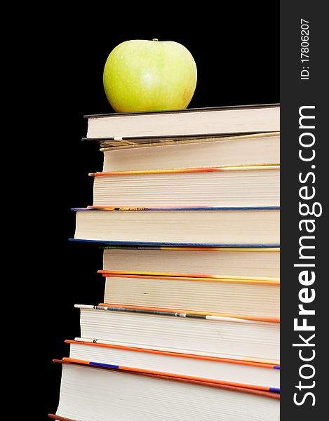 Stack Of Books And Apple On A Black Background