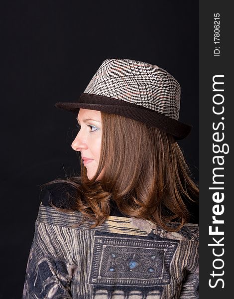 Charming young woman in a hat on black background. Charming young woman in a hat on black background