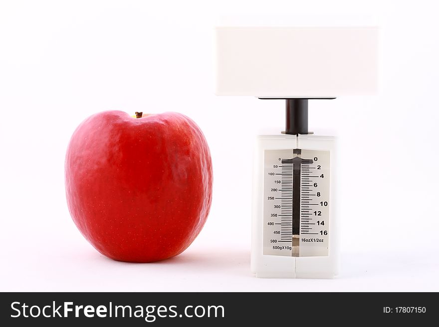 Dietic concept: red apple and white balance isolated on white
