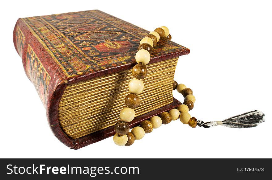 Ancient book and rosary on a white background