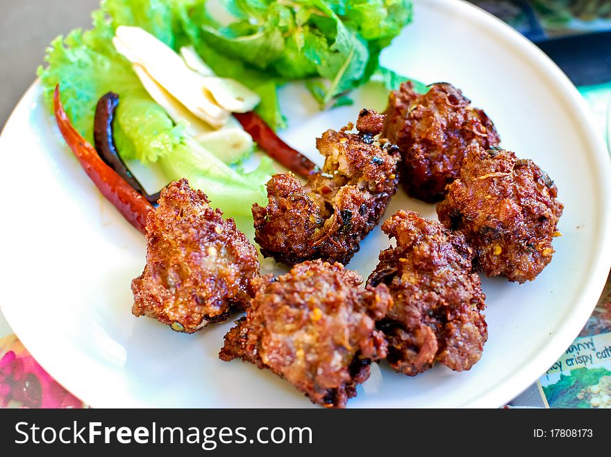 Thai style spicy pork ball fried serve with fresh vegetables