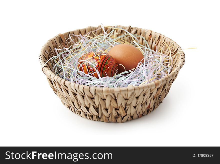 Painted and unpainted Easter eggs in the basket isolated on white
