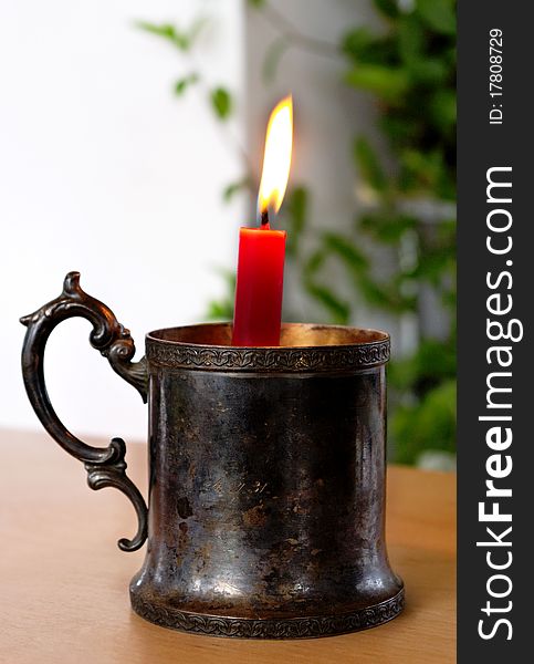 Candlestick with flaming candle on the table. Candlestick with flaming candle on the table.