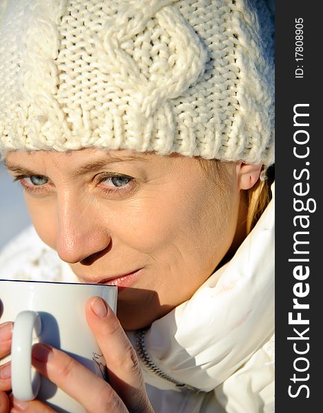 Portrait of adult women in white, with mug in his hands, bright sunny frosty day. Portrait of adult women in white, with mug in his hands, bright sunny frosty day