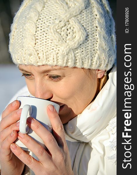 Portrait of adult women in white, with mug in his hands, bright sunny frosty day. Portrait of adult women in white, with mug in his hands, bright sunny frosty day