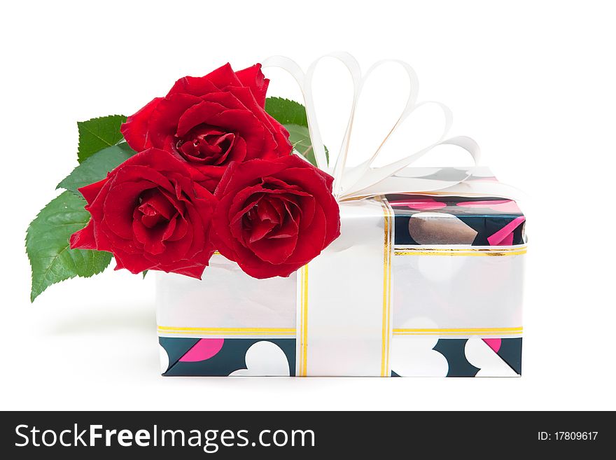 Gift decorated with ribbon and red roses isolated on white