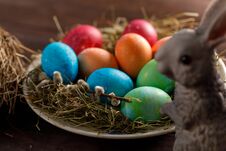 Easter Bunny And A Plate With Colored Eggs. Easter Celebration Concept Stock Photo