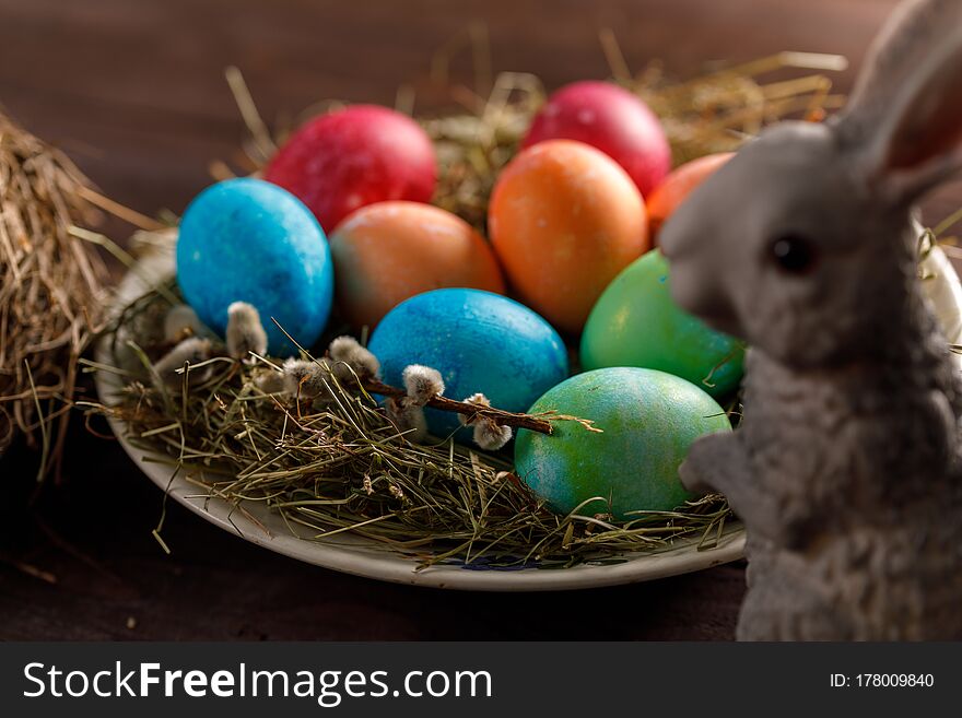 Easter bunny and a plate with colored eggs. Easter celebration concept. Close-up