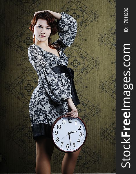 An image of a nice woman with a big clock. An image of a nice woman with a big clock