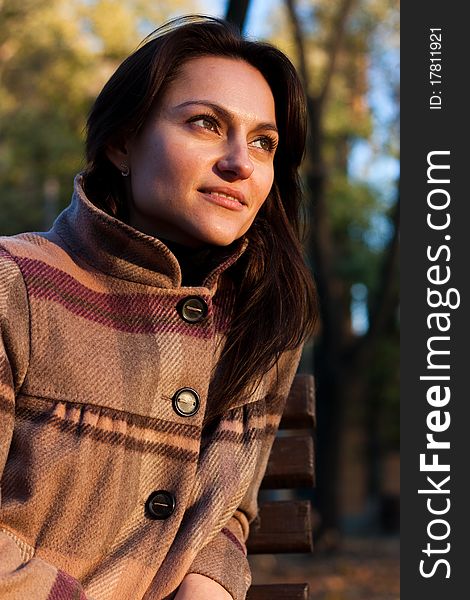 Beautiful young woman on a bench in autumn. Beautiful young woman on a bench in autumn