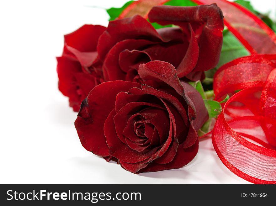 Red roses isolated on white background with red ribbon around it. Red roses isolated on white background with red ribbon around it.