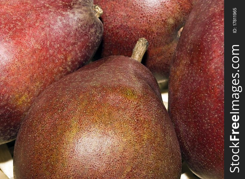 A close up of four red pears