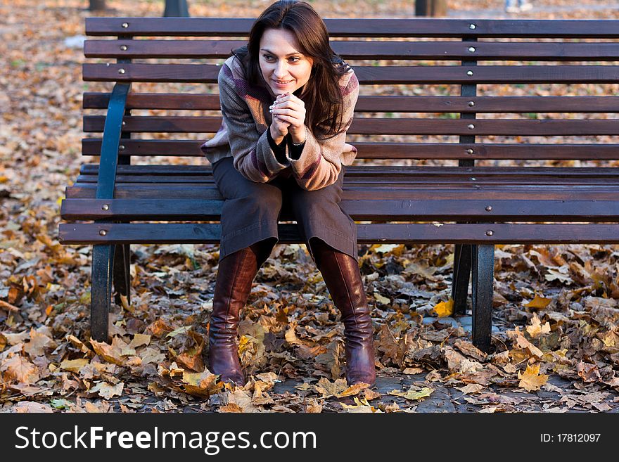 Beautiful young woman on a bench in autumn. Beautiful young woman on a bench in autumn