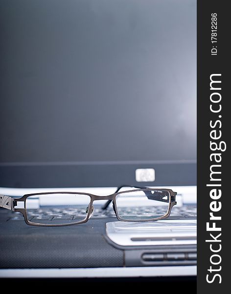 Business laptop with glasses in focus. Business laptop with glasses in focus