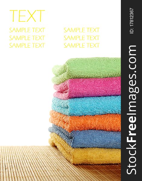 Lots of colorful bath towels stacked on each other. Isolated