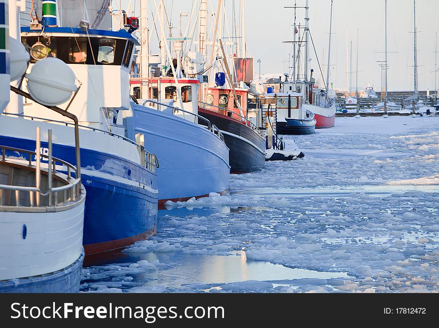 Fishing boats at dock in a frozen winter sea. Fishing boats at dock in a frozen winter sea
