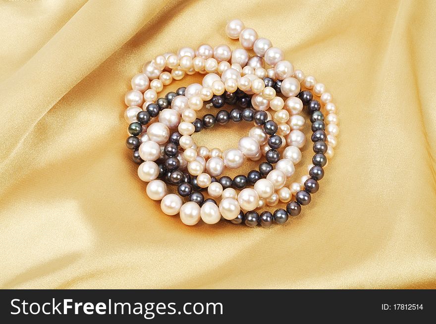 Gold silk background with pearl necklace on it. Gold silk background with pearl necklace on it