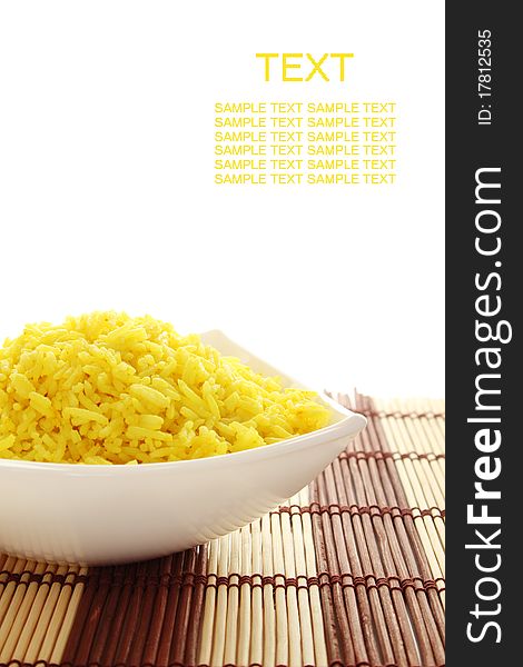 Boiled yellow rice boiled in white bowl. Plate stands on a wooden mat. Isolated on a white background. Boiled yellow rice boiled in white bowl. Plate stands on a wooden mat. Isolated on a white background