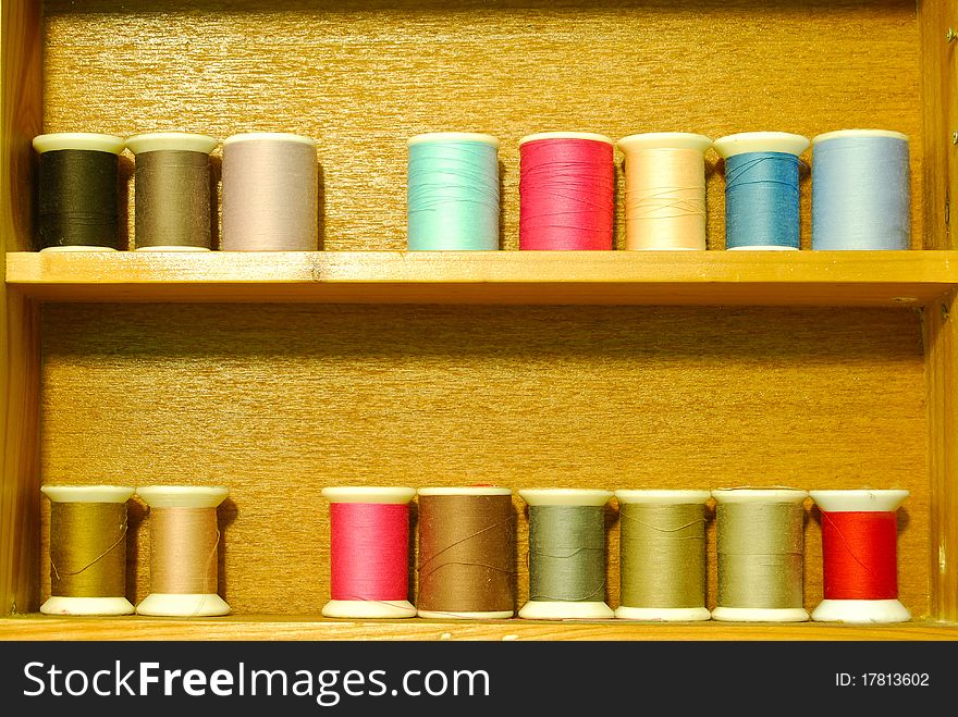 Colorful spool of thread on wood shelf